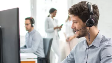 Hombre con audífonos trabajando en oficina