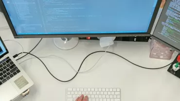 Trabajo en una estación de trabajo con portátiles y monitores que muestran código de programación.