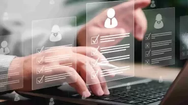 Una persona escribiendo en un portátil, con varios iconos mostrados en la pantalla, que indican aplicaciones o archivos activos.