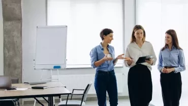 Profesionales reunidos revisando políticas salariales y gráficos de igualdad retributiva en un entorno corporativo moderno