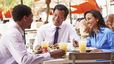 Tres personas disfrutando de una comida al aire libre.