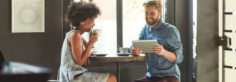 Un hombre y una mujer haciendo una entrevista informal tomando un café